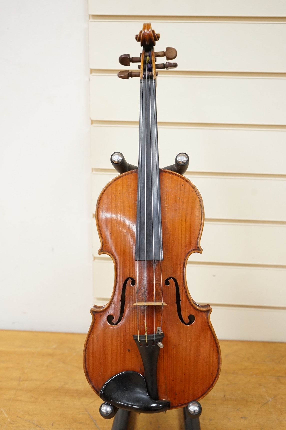 Three cased violins; a German Dresden violin, supplied by Campbell and co., Glasgow, together with another Dresden Stradivarius copy, and the remains of a European violin.